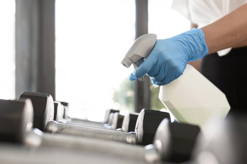 Employee cleaning gym equipment